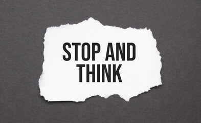 STOP AND THINK sign on the torn paper on the black background