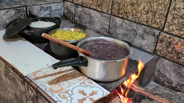 Feijoada cooked in a wood stove with rice and farofa