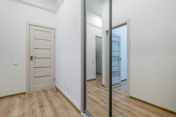 long empty corridor in interior of entrance hall of modern apartments, office or clinic with many doors