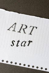 the words ART and star stencilled in black on notepaper with lines