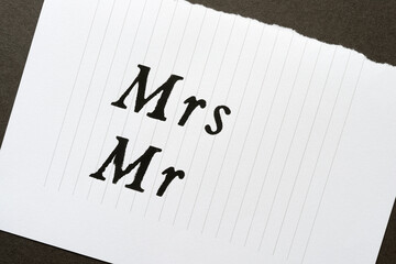 the abbreviations Mrs and Mr stencilled in black on blank note paper with lines