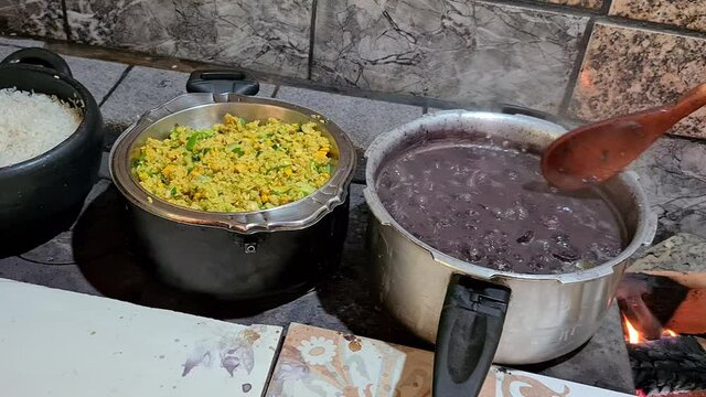 Feijoada cooked in a wood stove with rice and farofa