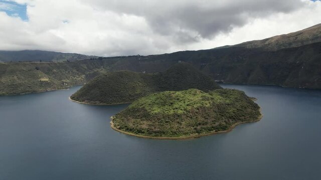 Flying over a pair of islands in the lagoon of a volcanic crater