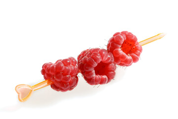 Red raspberry berries, pierced on canapes, close-up isolated on white