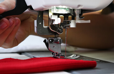 Close up of a tailor working on a sewing machine.process of sewing clothes on sewing machine. Close-up of needle for sewing.