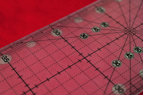 Closeup of tailor's patter on a red fabrics. Hobby and sewing concept. Handmade clothes concept. Tools for tailoring