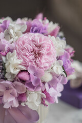 Bouquet with roses, hydrangea and a and lagurus. Stabilized flowers in a ceramic vase at home on the dressing table. Interior decor.