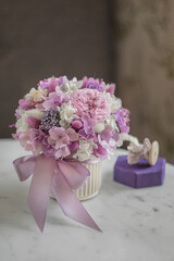 Bouquet with roses, hydrangea and a and lagurus. Stabilized flowers in a ceramic vase at home on the dressing table. Interior decor.