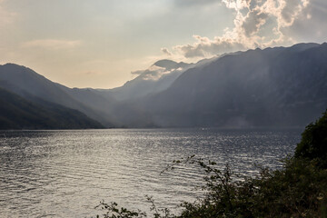 Foggy and cloudy evening in the Bay of Kotor. Seascape with sunset and mountains