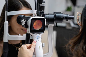 Doctora medico de la salud visual realizando un fondo de ojo con cámara retiniana 