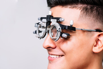 Primer plano de un Joven hombre con unas gafas de medición para realizar exámenes de la vista por el oftalmólogo 
