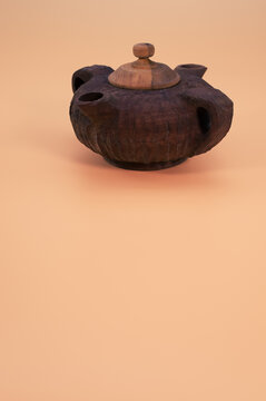 Beautiful brown teapot with two sprouts isolated on a beige background - free space for text
