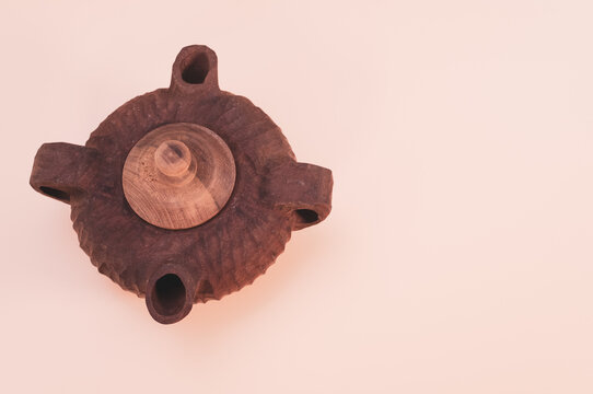Beautiful brown teapot with two sprouts isolated on a pink background - free space for text