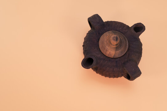 Beautiful brown teapot with two sprouts isolated on a beige background - free space for text