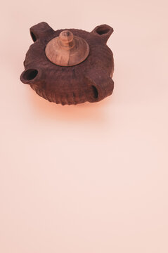 Beautiful brown teapot with two sprouts isolated on a pink background - free space for text