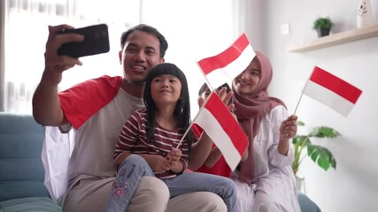 indonesian muslim family making selfie and video call using their phone at home