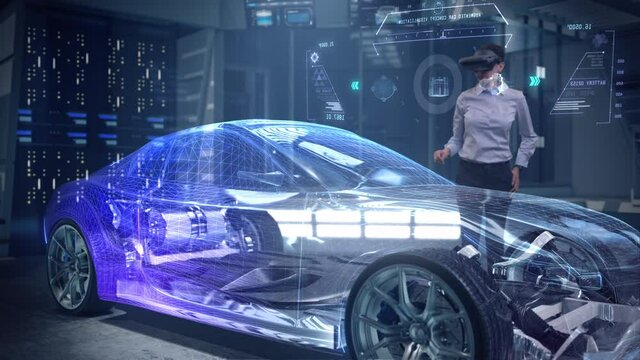 Automotive Female Professional Engineer working on design of Electric Car using Futuristic Augmented Reality Headset with Holographic Technology at High-tech facility. Electric car chassis.