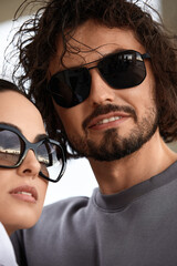Beautiful couple man woman in sunglasses, lifestyle, modern passionate young couple in glasses hug and smile