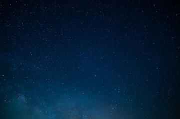 Night starry sky. Many small bright stars twinkle against the deep blue sky. There are no people in...