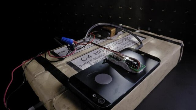 MALE HANDS ARMING A C4 PLASTIC EXPLOSIVE DEVICE.  ECU SLIDER SHOT IN 4K.