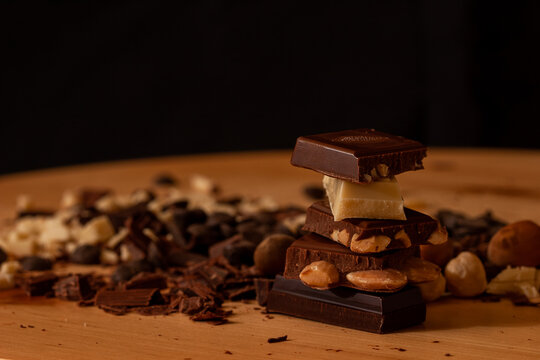close-up of stack of chocolate ounces against a black background.