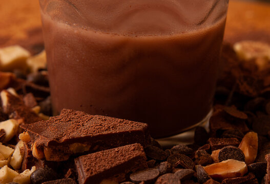 Close-up of pieces of chocolate with almonds and a milkshake.
