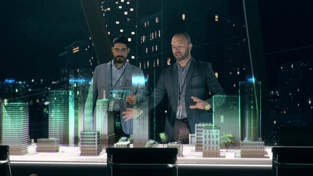 In the Near Future: Professional Designer in Suit Working on Architecture Project with Partner standing around Futuristic Table Using Holographic Modern Augmented Reality Technology.