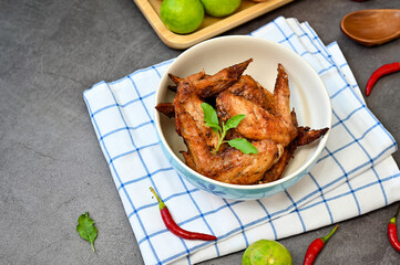Herb-roasted chicken wings in a cup placed on table, food background with copy space 
