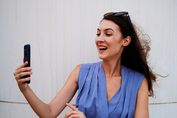 Happy woman on call using mobile cell phone while looking at front camera while smiling   - Powered by Adobe