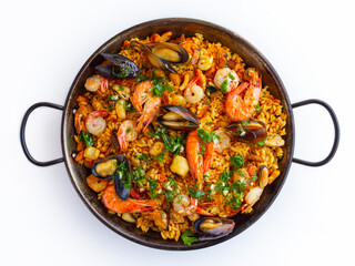 Traditional spanish seafood paella with rice, mussels, shrimps in a pan on white background. view from above, flat lay - obrazy, fototapety, plakaty