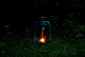 lantern. a lantern lit in a dark forest