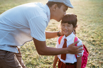 primary school student kiss her father hand when going to school