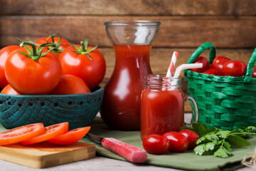 bowl and basket with ripe tomatoes next to tomato juice on the table