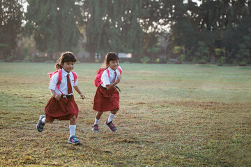 Obraz premium little girl student running together while going to their school