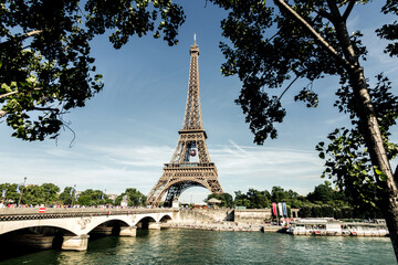 Fototapeta na wymiar eiffel tower seen from the other side of the seine river between trees
