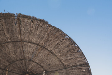 Straw umbrellas and sunbeds on the beach of Illetes in Formentera, Spain.