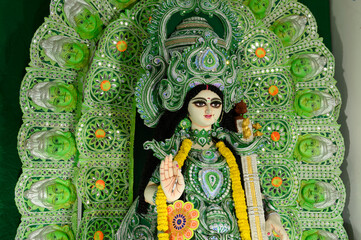 Idol of Goddess Saraswati being worshipped inside pandal , a temporary temple, at night. Colorful...