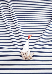 Wooden raft with a white sails on a sailor's shirt instead of the sea. Rectangle layout.