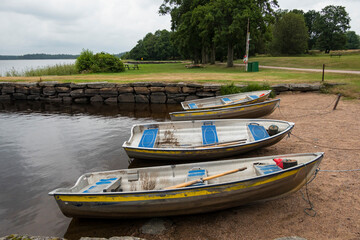 Naklejka na ściany i meble Hofsnas, Sweden Three rowboats parked on a small beach.