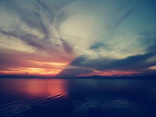 a red sunset divided by blue clouds over the water surface