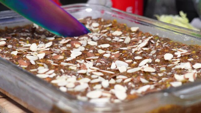 Slicing Freshly Baked Caramel Banana Cake With Almond Nut Toppings. - Closeup Shot