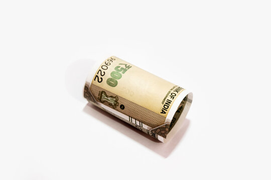 Indian five thousand rupees rolled up banknote isolated on white background.