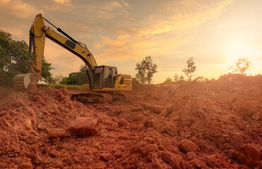 Backhoe working by digging soil at construction site. Bucket teeth of backhoe digging soil. Excavator digging on earth. Excavating machine. Earthmoving machine. Backhoe for rental business background. - obrazy, fototapety, plakaty