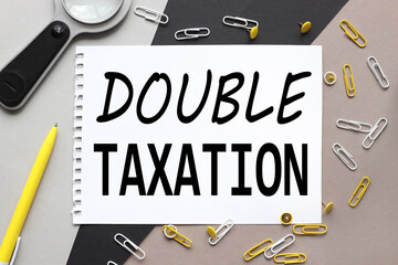 Double Taxation, notepad on a background of different colors. brown, black, gray