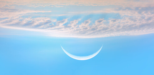 New moon (crescent) under the white bright clouds with blue sky in the background © muratart