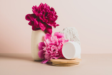 Cosmetic products in various jars and tubes abstract modern background. Podium from natural materials fresh flowers