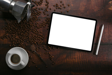 Mock up digital tablet, coffee cup and roasted coffee beans on wooden background.