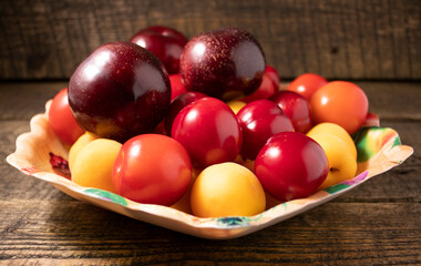 Plums,plums and apricots on a wooden table.Fresh, juicy fruits on a wooden background.