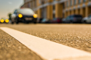 Road near luxury mansion, on the street passing cars. Close up view from the level of the dividing line