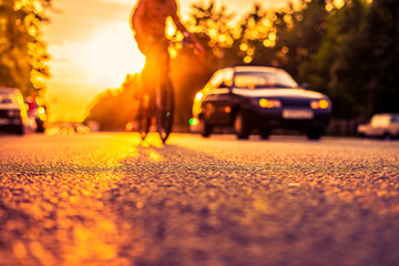 Sunset in the suburbs, the car and a bicycle traveling on the highway. Close up view from the...